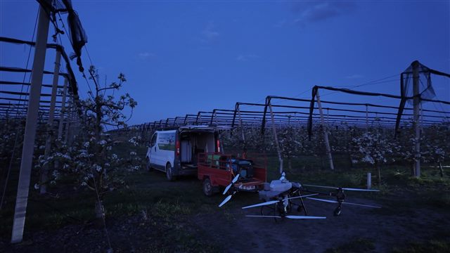 Drone and support equipment in a flowering orchard