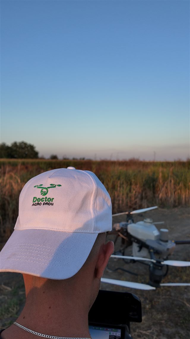 Pilot beside an agricultural drone — open photo